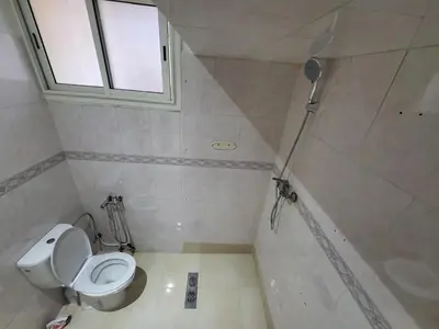 a bathroom with a toilet and a shower with a window at Maison 2pc plain-pied -centre in Rabat