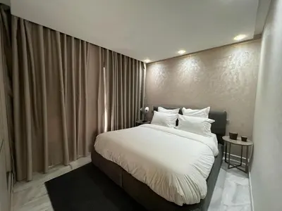 a bedroom with a large bed with white sheets and pillows at Appartement luxueux au bord du mer in Casablanca