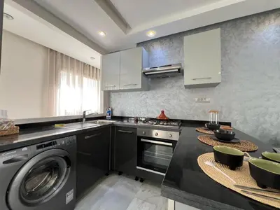 a kitchen with a washing machine and a washer at Appartement luxueux au bord du mer in Casablanca
