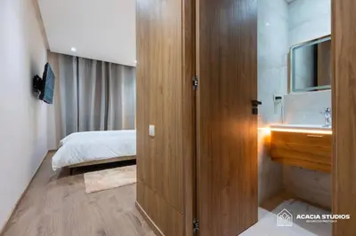 a bathroom with a wooden door leading to a bedroom at Acacia Studio 01 in Casablanca