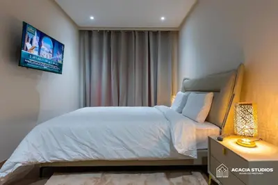 a bedroom with a bed and a tv on the wall at Acacia Studio 02 in Casablanca