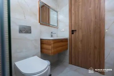a bathroom with a toilet and a sink and a wooden door at Acacia Studio 02 in Casablanca