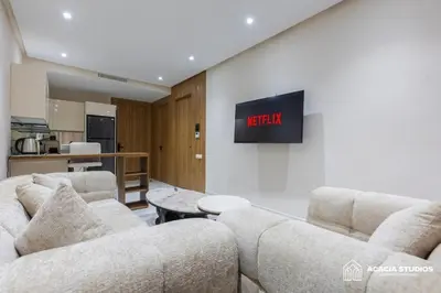 a living room with two couches and a tv on a wall at Acacia Studio 03 in Casablanca