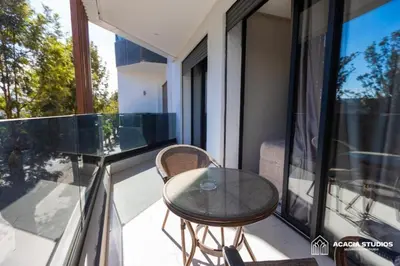 a glass table on a balcony with a table and chairs at Acacia Studio 07 in Casablanca