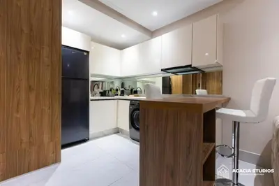 a kitchen with white cabinets and a black refrigerator at Acacia Studio 11 in Casablanca