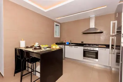 a kitchen with white cabinets and a black counter top at Beyti in Rabat