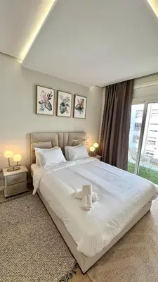 a bedroom with a large white bed with two towels on it at N28 3 Bedrooms & Private Gym just walking to Stade Moulay Abdellah in Rabat