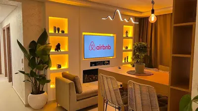 a living room with a table and a tv on a wall at N28 3 Bedrooms & Private Gym just walking to Stade Moulay Abdellah in Rabat