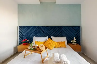 a bedroom with a large bed with yellow pillows at Appartement de Luxe - Piscine et Accès à la Plage in Bouznika