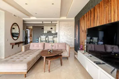 a living room with a couch and a table at Appartement de Luxe - Piscine et Accès à la Plage in Bouznika