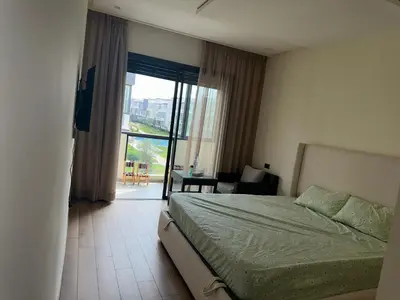 a bedroom with a bed and a view of a balcony at Appartement Les Crêtes in Casablanca