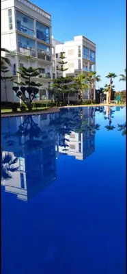 a large pool of blue water in front of a building at Bouznika rabat in Bouznika