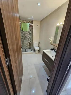 a bathroom with a toilet and a sink and a mirror at Bouznika rabat in Bouznika