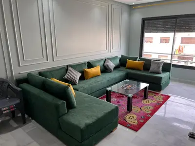 a living room with a green couch and a table at Studio de la perle in Casablanca
