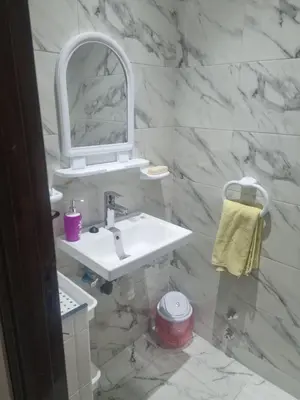 a white bathroom with a sink and a mirror at Bayt El Fath in Casablanca