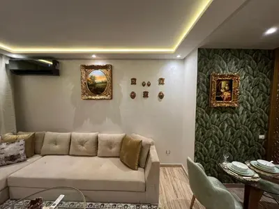 a living room with a couch and paintings on the wall at Studio proche clinique akdital ain sebaa in Casablanca