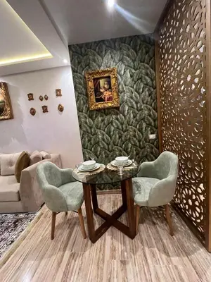 a dining room with a table and two chairs at Studio proche clinique akdital ain sebaa in Casablanca