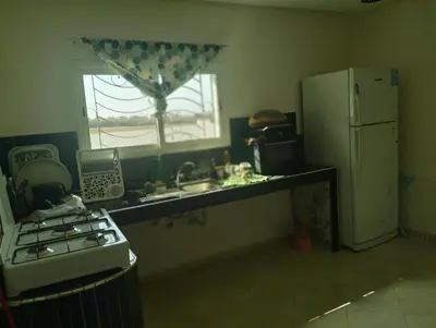 a kitchen with a stove and a sink and a refrigerator at RiadNA in Bouznika