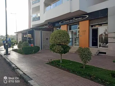 a building on a street with trees in front of it at Appartement de luxe à 3 min de l aéroport in Nouaseur