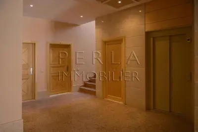 a hallway with two doors and stairs in a building at Appartement de luxe à 3 min de l aéroport in Nouaseur