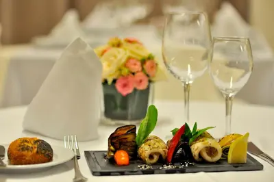 a plate of food on a table with two wine glasses at Kenzi Sidi Maarouf in Casablanca
