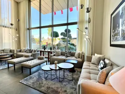 a living room with couches and tables and a large window at Kenzi Sidi Maarouf in Casablanca