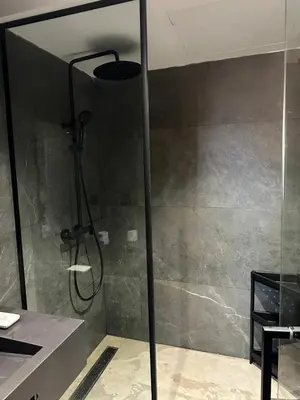 a shower with a glass door in a bathroom at Luxury 1-Bedroom Apartment in Casablanca