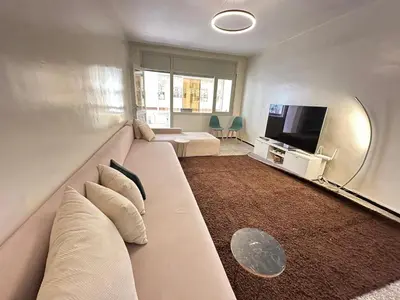 a living room with a large couch and a tv at 3Bed-Room Appart Agdal City Center in Rabat