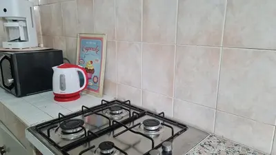 a stove top oven in a kitchen with a microwave at 3Bed-Room Appart Agdal City Center in Rabat