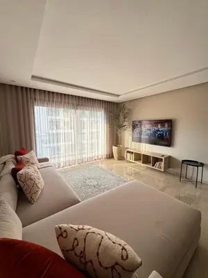 a living room with a white couch and a tv at Minimalist Escape - Between Rabat Agdal Station & Corniche in Rabat
