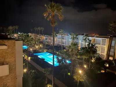 a view of a swimming pool at night at Beachside Charming Apartment in Tamaris