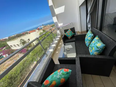 a balcony with couches and a view of the ocean at Beachside Charming Apartment in Tamaris