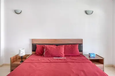 a bedroom with a red bed with red pillows at Appartement Agdal, proche des stades in Rabat