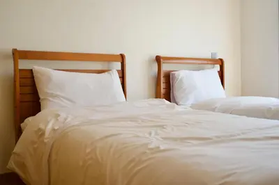 two beds in a room with white sheets and pillows at Stylish Luxe Apartment Casablanca Finance City! in Casablanca