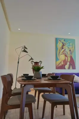 a dining room table with chairs and a lamp at Stylish Luxe Apartment Casablanca Finance City! in Casablanca
