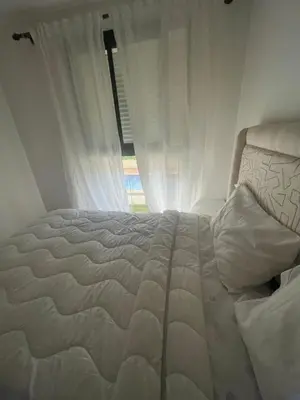 a white bed in a room with a window at Studio moderne et élégant Idéal pour un séjour confortable in Rabat