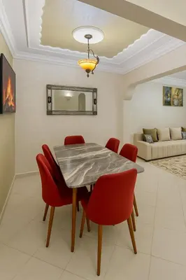 a dining room with a table and red chairs at Modern hideaway in Casablanca in Casablanca