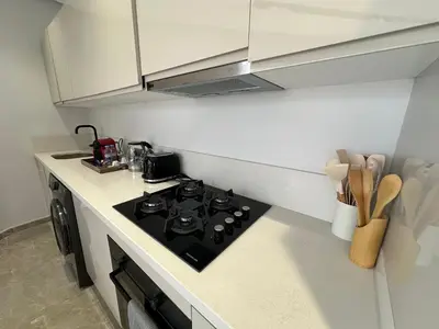 a kitchen with a black stove top in a kitchen at Casablanca Maarif 1BR With Private Patio And Parking in Casablanca