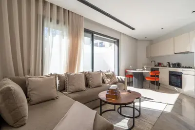 a living room with a couch and a table at Casablanca Maarif 1BR With Private Patio And Parking in Casablanca