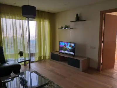 a living room with a flat screen tv on a table at Stunning one bedroom flat at Casablanca Marina 10th floor Sea View in Casablanca
