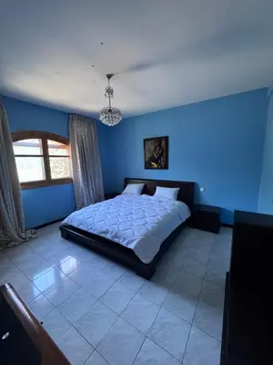 a blue bedroom with a bed and a window at Villa élégante à Rabat,harhoura à 4 chambres in Rabat