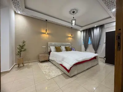 a bedroom with a large bed in a room at Moderne berlin av terrasse in Rabat