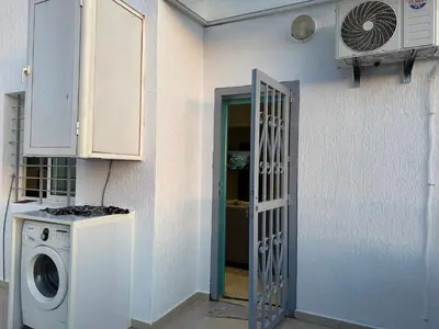 a laundry room with a washing machine and a door at Moderne berlin av terrasse in Rabat