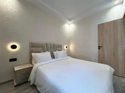 a bedroom with a large bed with white sheets at Functional and Stylish Apartment in Agdal for Rabat Stay in Rabat