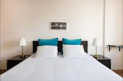 a bedroom with a white bed with blue pillows at Tranquil in Casablanca