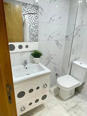 a white bathroom with a sink and a toilet at The Park Apartment in Mohammedia
