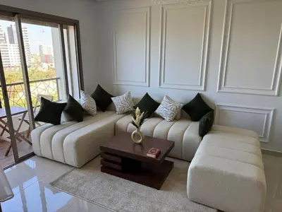 a living room with a couch and a coffee table at Évasion zen près de Casablanca - Vue imprenable sur le parc et la plage de l'Éco City Zenata in Aïn Harrouda