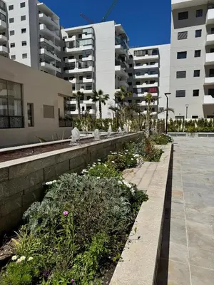 a walkway in a city with some plants and buildings at Évasion zen près de Casablanca - Vue imprenable sur le parc et la plage de l'Éco City Zenata in Aïn Harrouda