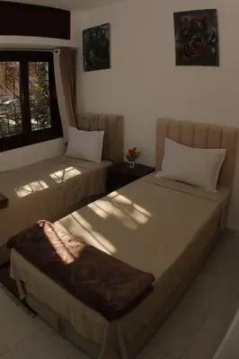 a bedroom with two beds and a window at Apartment Nahda Rabat in Rabat