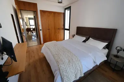 a bedroom with a bed and a desk with a television at Appartement chic et cosy - Casablanca Finance City in Casablanca